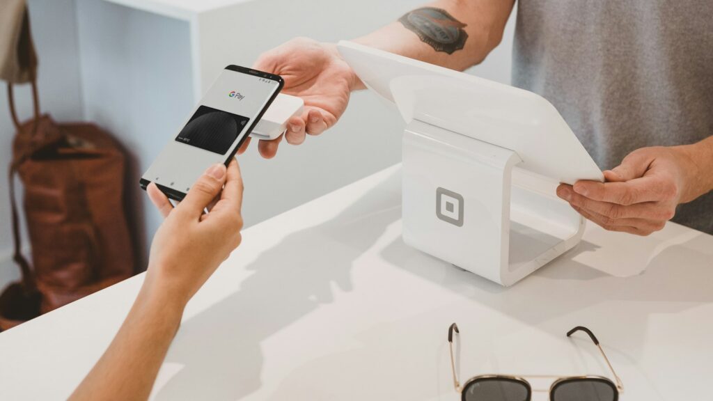 Shopper paying with a phone at a store checkout counter