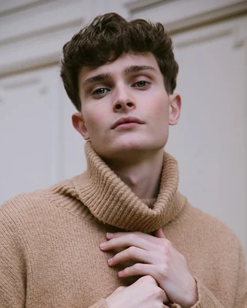 Man in a camel turtleneck sweater