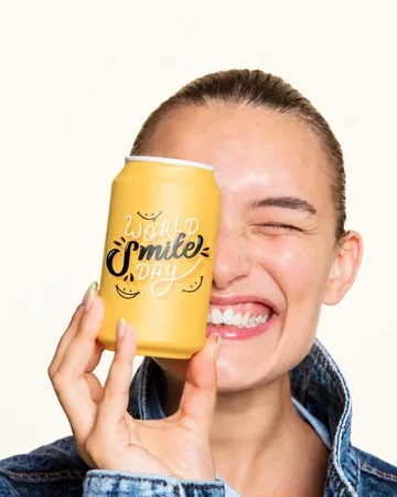 Laughing woman holding a yellow drinks can